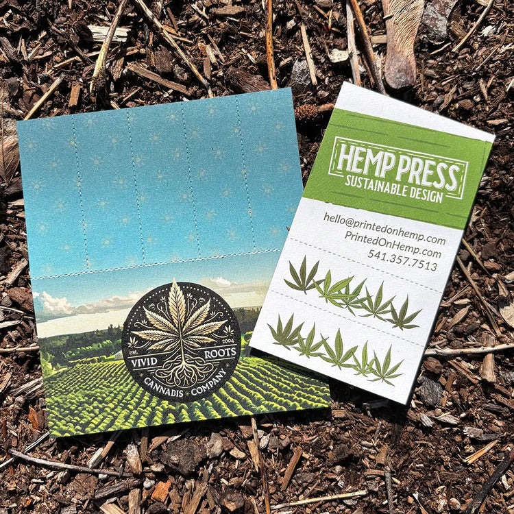 Two custom Crutch Cards on soil—one for Vivid Roots Cannabis with perforated tips, one for Hemp Press with hemp leaf design and contact info.