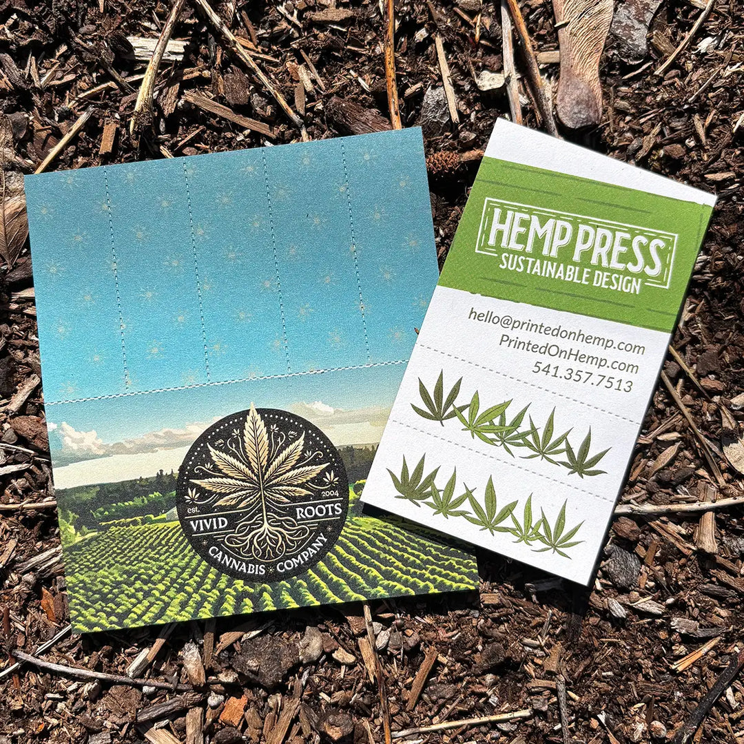 Two custom Crutch Cards on soil—one for Vivid Roots Cannabis with perforated tips, one for Hemp Press with hemp leaf design and contact info.