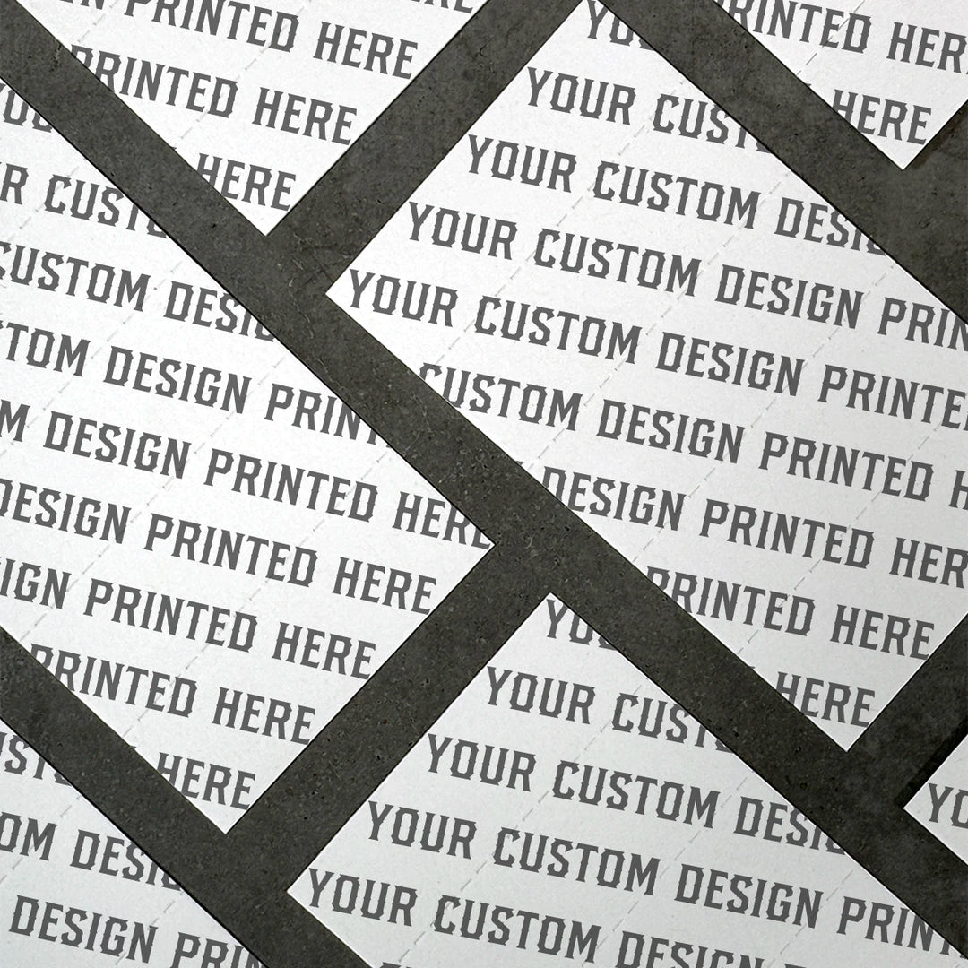 Close-up of perforated hemp paper sheets printed with the repeating phrase “YOUR CUSTOM DESIGN PRINTED HERE,” arranged diagonally with dark grid lines separating each card.